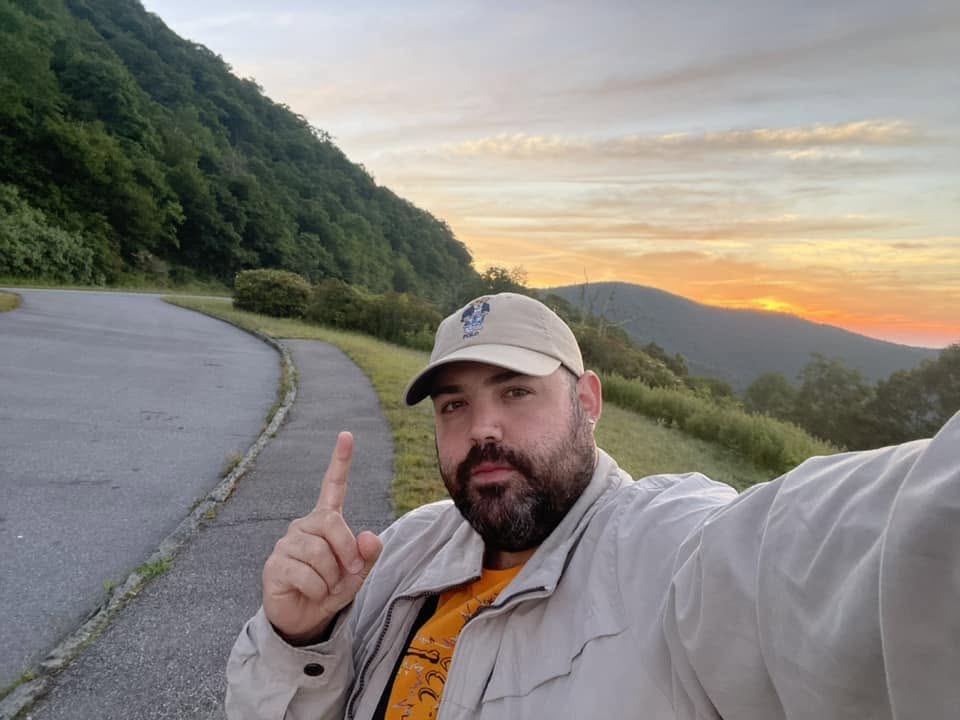 John Ge, recovery coach, at sunrise on a mountain overlook